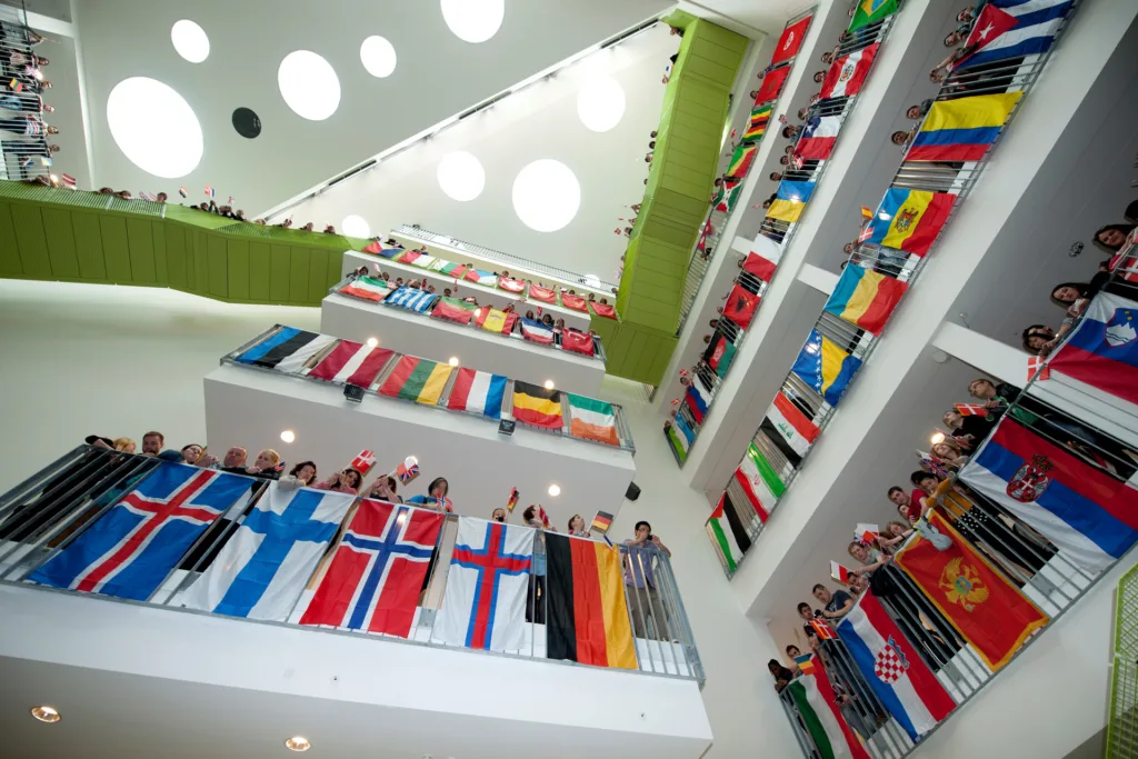 Študenti s vlajkami svojich krajín na ochodzách átria VIA University College