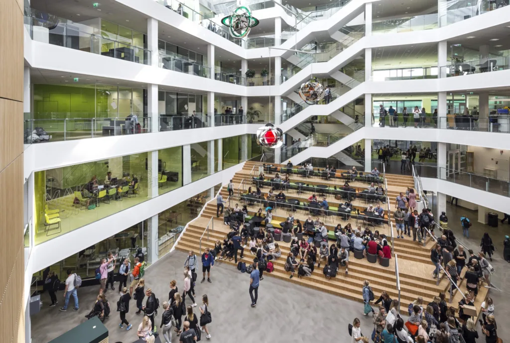 Átrium kampusu VIA University College v Aarhuse so schodiskovým hľadiskom plným študentov